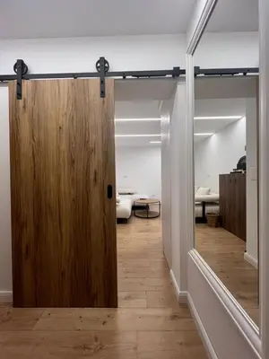 a sliding door in a room with a bedroom at Kolodvor 1870 - Old Town Apartment Kranj in Kranj