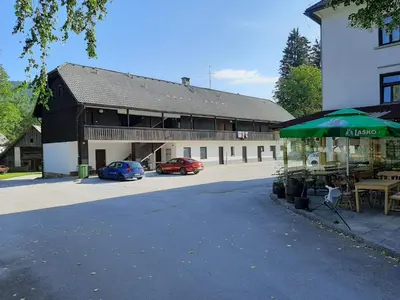 a building with two cars parked in a parking lot at Apartma Bučko in Bohinj
