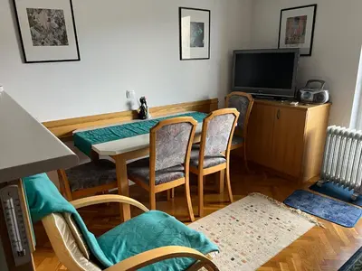 a dining room with a table and chairs and a television at Apartma Bučko in Bohinj