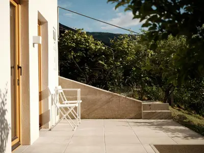 a white chair sitting on the porch of a house at Peak & Pause in Bistrica pri Limbušu