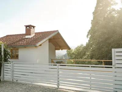 a white fence in front of a house at Peak & Pause in Bistrica pri Limbušu