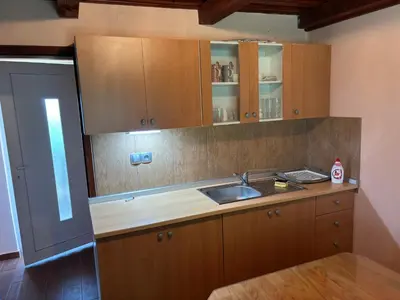 a kitchen with wooden cabinets and a sink at Apartment Haloze in Videm pri Ptuju