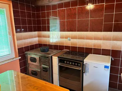 a small kitchen with a stove and a refrigerator at Apartment Haloze in Videm pri Ptuju