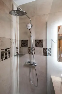 a shower with a shower head in a bathroom at House Dorče in Kojsko