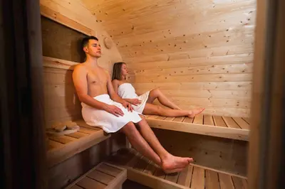 a man and woman sitting in a sauna at Private SPA with jacuzi, sauna & EV charging in Kranj