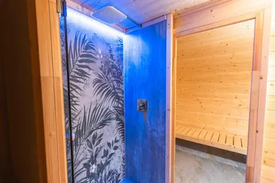 a sauna with a blue wall in a house at Private SPA with jacuzi, sauna & EV charging in Kranj