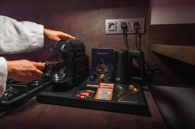 a person is making a drink in a coffee machine at Private SPA with jacuzi, sauna & EV charging in Kranj