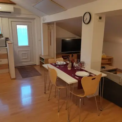 a kitchen and dining room with a table and chairs at Apartment Swan in Bled