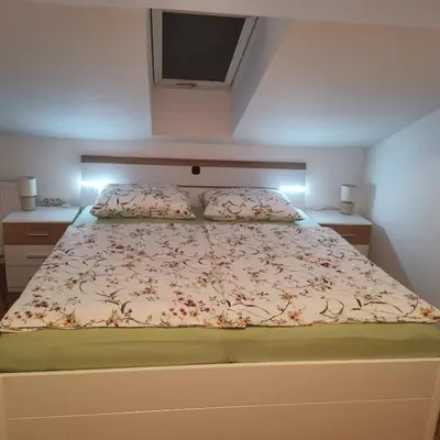 a bedroom with a large bed with a tv on it at Apartment Swan in Bled