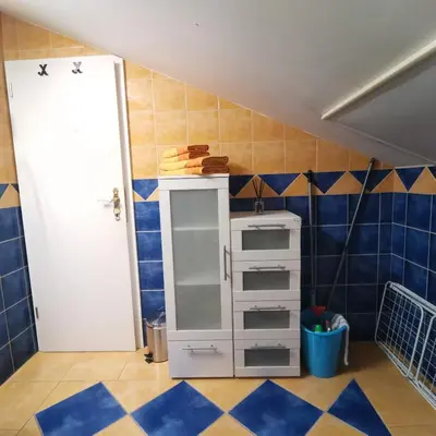 a room with a white cabinet and blue tiles at Apartment Swan in Bled