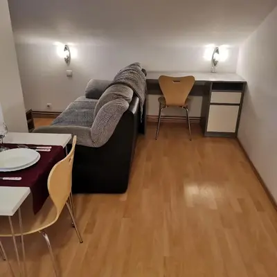 a living room with a couch and a table and chairs at Apartment Swan in Bled