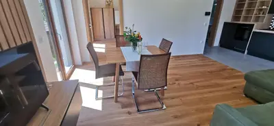 a dining table and chairs in a living room at Apartment Ratek in Ivanjkovci