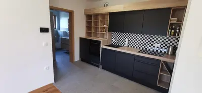 a kitchen with black cabinets and a counter top at Apartment Ratek in Ivanjkovci
