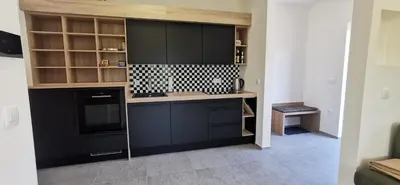 a kitchen with black cabinets and a stove at Apartment Ratek in Ivanjkovci