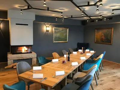 a room with a table and chairs and a fireplace at Guesthouse Tolc in Spodnja Sorica