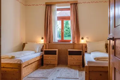 two twin beds in a room with a window at Apartmaji Sitar in Ribnica na Pohorju