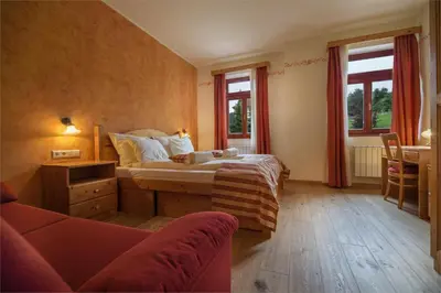 a bedroom with a bed and a couch and windows at Apartmaji Sitar in Ribnica na Pohorju