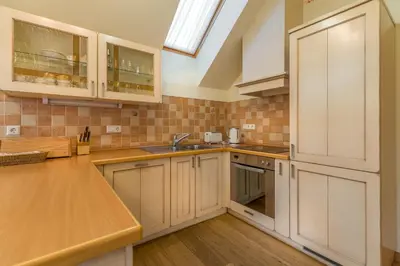 a kitchen with white cabinets and a sink at Apartmaji Sitar in Ribnica na Pohorju