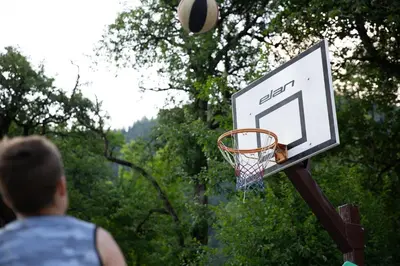 a man throwing a basketball into a hoop at Turistična Kmetija Zgornji Zavratnik in Luče