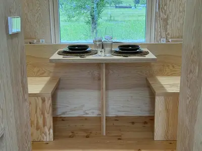 a small table with two glasses and plates on it at Telaj Residence - Cosy Cabins near Bovec, Soča Valley in Bovec