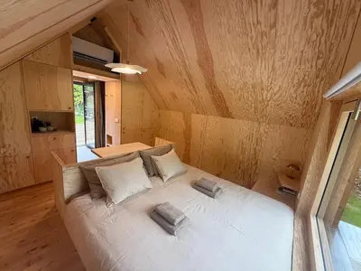a large white bed in a room with wooden walls at Telaj Residence - Cosy Cabins near Bovec, Soča Valley in Bovec