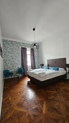a bedroom with a large bed and a wooden floor at Center flat 160m2 in Ljubljana