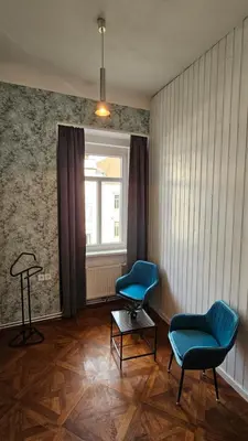 two chairs and a table in a room with a window at Center flat 160m2 in Ljubljana