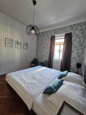 a bedroom with a large white bed and a window at Center flat 160m2 in Ljubljana