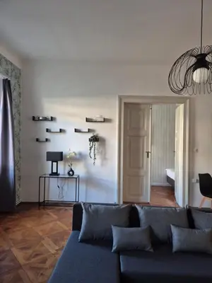a living room with a blue couch and a chandelier at Center flat 160m2 in Ljubljana