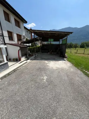 a large building with a garage next to a field at Stanojkov 2 in Bovec