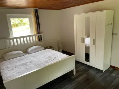 a bedroom with a large white bed and a window at Eko kmetija Sen na Zgornji Kapli in Zgornja Kapla