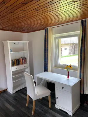 a desk and a chair in a room with a window at Eko kmetija Sen na Zgornji Kapli in Zgornja Kapla