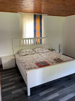 a white bed in a bedroom with a window at Eko kmetija Sen na Zgornji Kapli in Zgornja Kapla