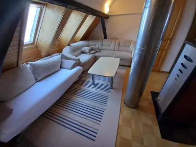 a living room with a couch and a table at Tubej apartments in Bohinj