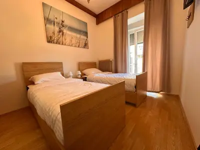 a bedroom with two beds and a window at Ludanov apartma in Radlje ob Dravi