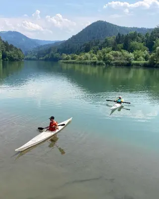 two people are in kayaks on a lake at Ludanov apartma in Radlje ob Dravi