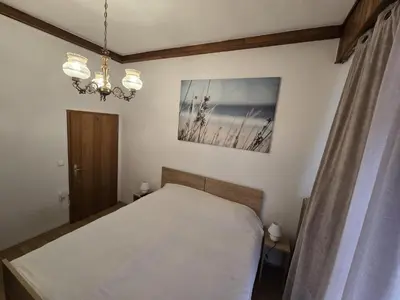 a bedroom with a bed and a chandelier at Ludanov apartma in Radlje ob Dravi