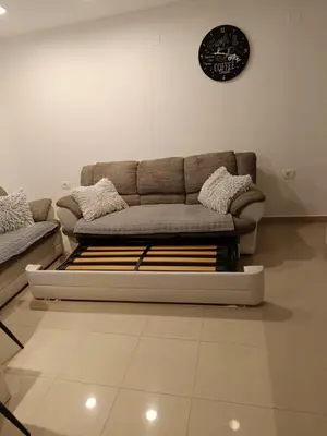 a living room with a couch and a clock on the wall at Apartments Dani in Postojna