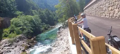a person standing on a bridge next to a river at Apartma Saint Thomas in Selca