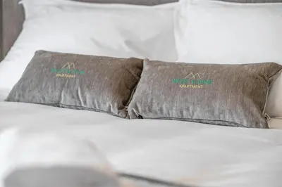 a bed with two pillows on top of it at West Alpine Apartment SKI in&out in Kranjska Gora