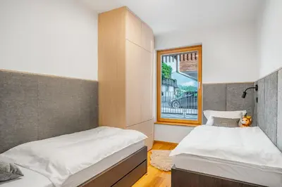 two beds in a room with a window at West Alpine Apartment SKI in&out in Kranjska Gora