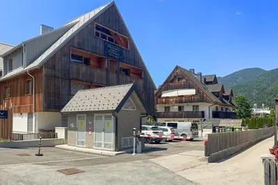 a large building with a parking lot in front of it at West Alpine Apartment SKI in&out in Kranjska Gora
