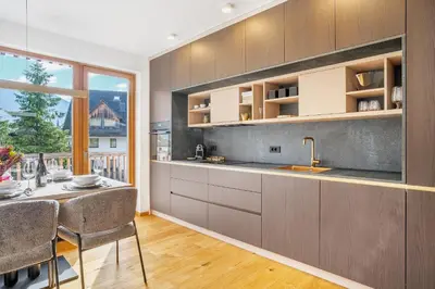 a kitchen with a table and chairs and a window at West Alpine Apartment SKI in&out in Kranjska Gora