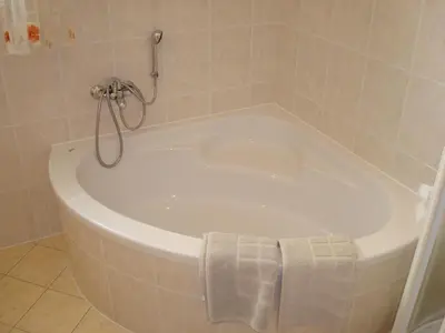 a white bath tub in a bathroom with a towel at Apartment Kotnik in Kamnik
