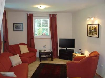 a living room with two red chairs and a television at Apartment Kotnik in Kamnik