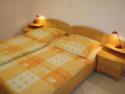 a bedroom with a wooden bed with two pillows at Apartment Kotnik in Kamnik