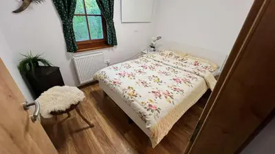 a small bedroom with a bed with a floral blanket at Apartment Olga