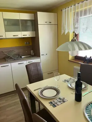 a kitchen with a table with a bottle of wine at Kozjanski odklop in Buče
