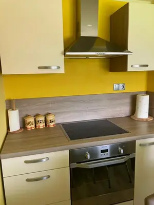 a kitchen with yellow walls and a stove top oven at Kozjanski odklop in Buče
