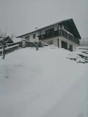 a house with a snow covered yard in front of it at Kozjanski odklop in Buče